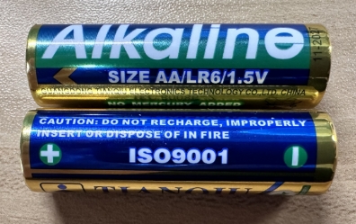 Close-up image of AA alkaline batteries (LR6, 1.5 V), illustrating the correct battery type recommended for KE100.