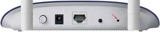 A photo of the back of an access point, with an arrow pointing to the reset hole.