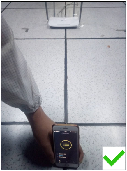 Person holding a smartphone with the Tether app open at the same height as a TP-Link router, with a green checkmark.