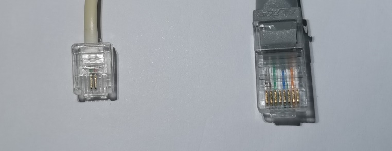 Photo comparing a smaller RJ11 connector and a larger RJ45 connector side by side.