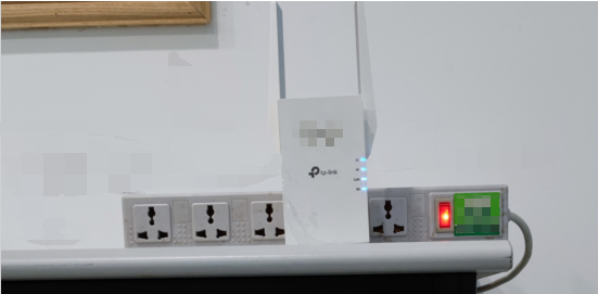 Photo showing extender plugged into a power strip with antennas positioned vertically.