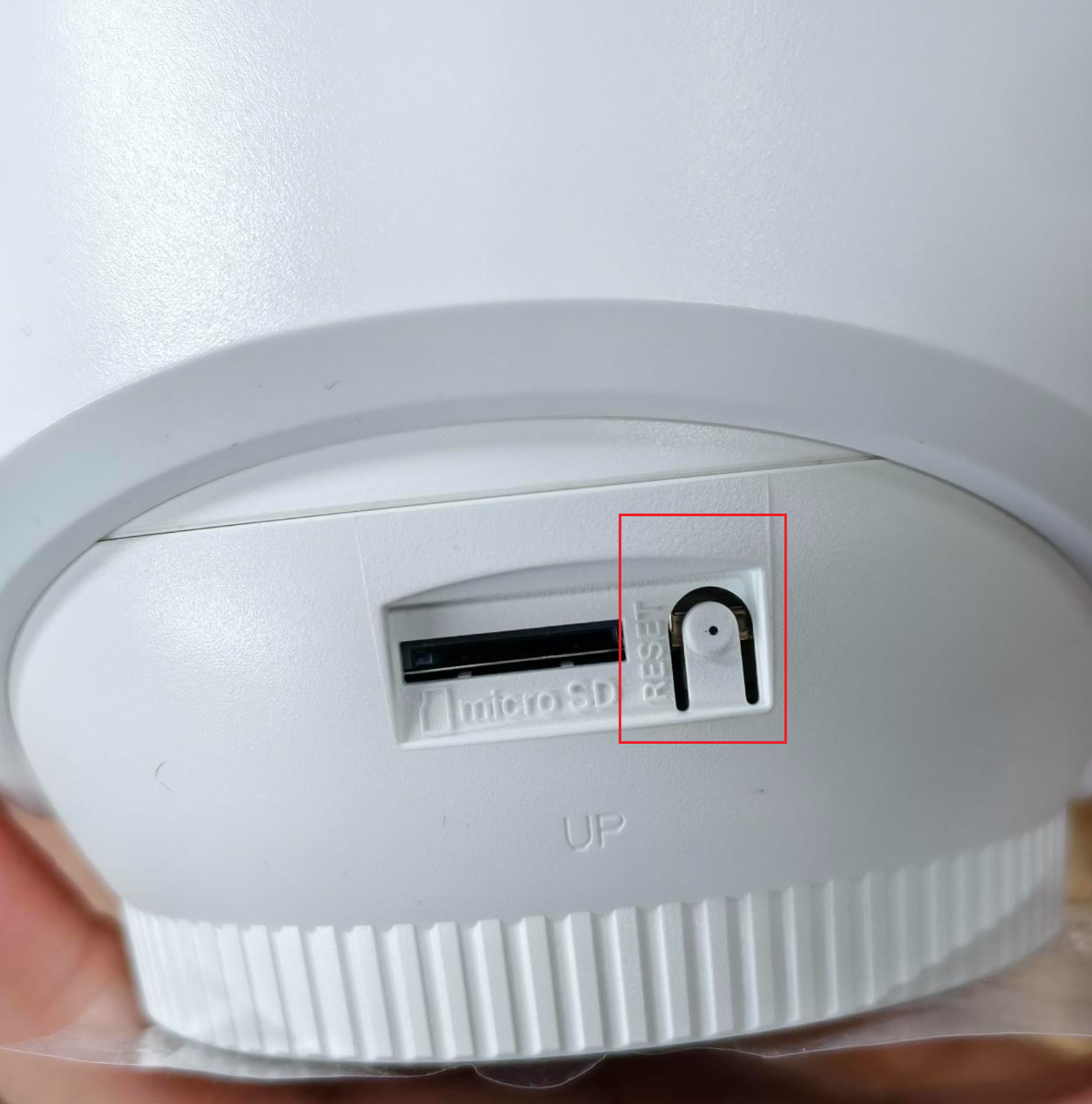 Showing reset button next to the microSD card slot on the camera.