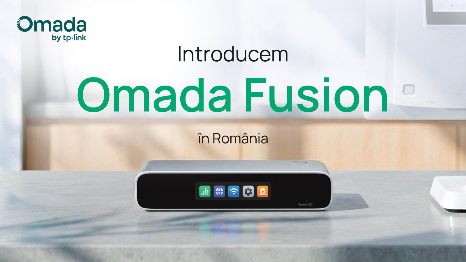Imagine generică tip lifestyle cu produsul Omada Fusion 2.5G aflat pe o masă în centrul imaginii, cu mobilier în fundal și o parte dintr-un monitor în dreapta